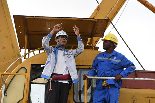 An engineer from China Communications Construction Co Ltd talks with a Kenyan colleague at a port construction site in Kenya. (Photo/Xinhua)