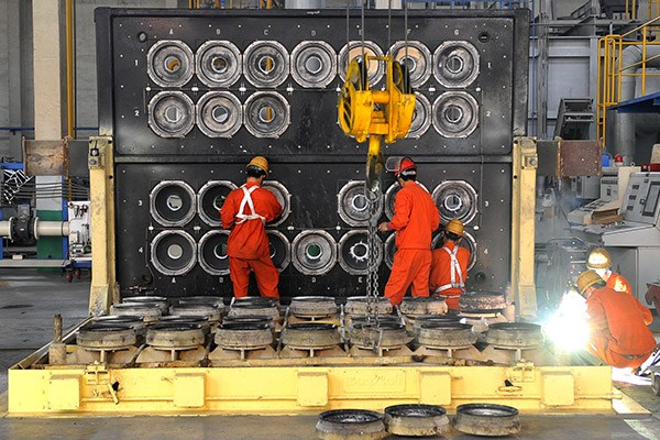 Workers process aluminum materials in a Zhongwang workshop in Liaoning province. (Photo/Xinhua)