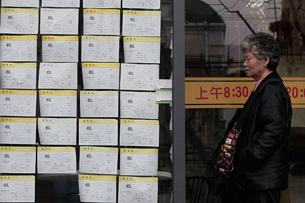 A citizen checks house leasing information on Xiangyang Road, Shanghai.(Gao Zheng/for China Daily)