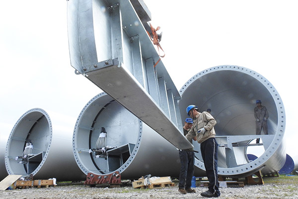 Technicians install wind power facilities in Lianyungang, East China's Jiangsu province. (Geng Yuehe/for China Daily)