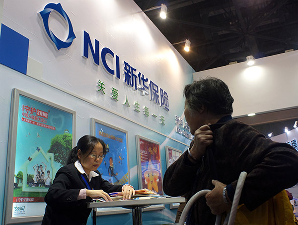 An executive of New China Life Insurance explains the firm's products to a potential customer. (Lang Sha/for China Daily)