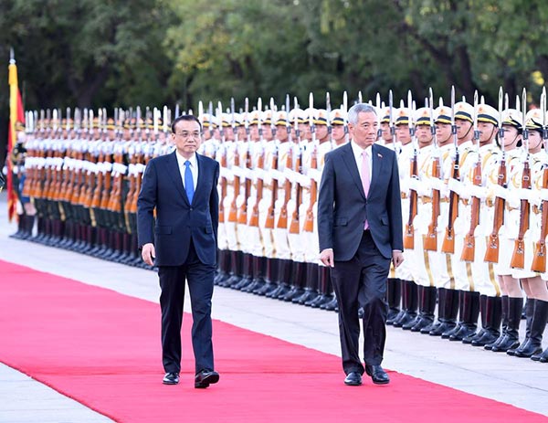 Premier Li Keqiang (L) holds a welcome ceremony for Singaporean Prime Minister Lee Hsien Loong before their talks in Beijing, Sept 19, 2017. (Photo/Xinhua)
