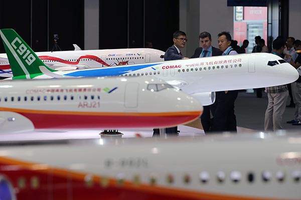 Visitors look at a model of the Chinese-built C919 passenger plane at the 17th China Aviation Expo in Beijing on Tuesday. WANG ZHUANGFEI/CHINA DAILY