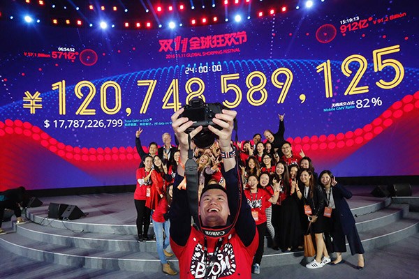 Staff of Alibaba's online shopping platform Tmall cheer as its sales volume surpasses 120 billion yuan during the Singles Day shopping spree in 2016. (Photo/Xinhua)