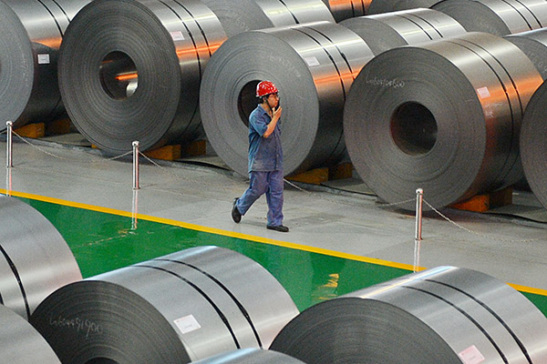 A worker patrols the steel coil repository at HBIS Group's Hansteel Co. (Photo/Xinhua)