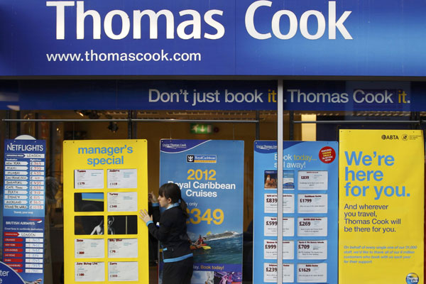 A worker changes the window display of Thomas Cook in Loughborough, central England.(Photo provided to China Daily)