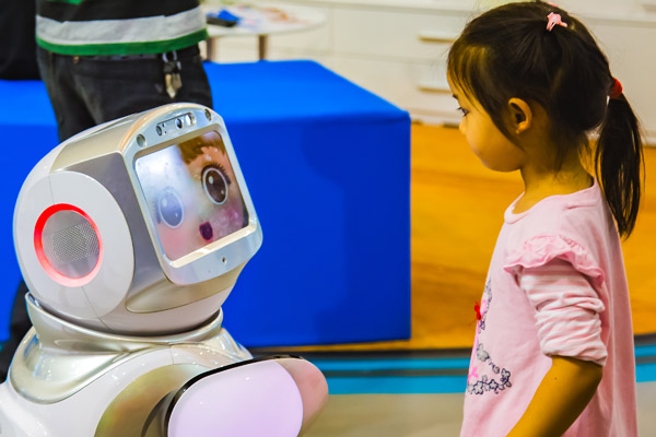 A robot powered by artificial intelligence interacts with a child at a recent tech and innovation expo in Nanjing, Jiangsu province. (Photo provided to China Daily)