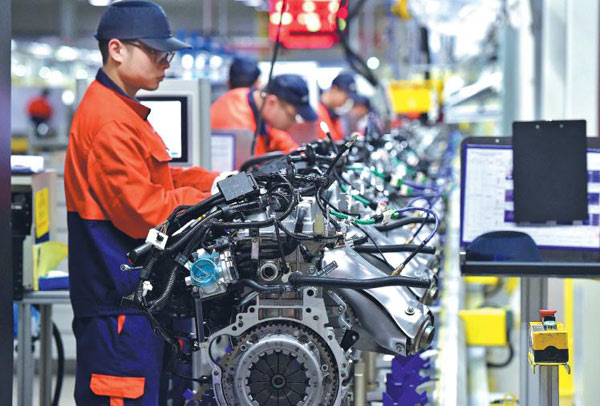 Workers assemble auto parts destined for Geely models at a production line of an engine company in Zhejiang province. (Photo by Lyv Bin/For China Daily)