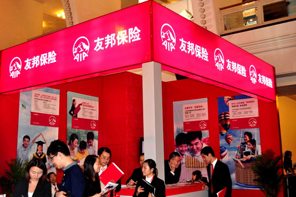 AIA Life Insurance executives explain their products to visitors to the Money Fair Shanghai 2014. (Photo by Yan Daming/China Daily)
