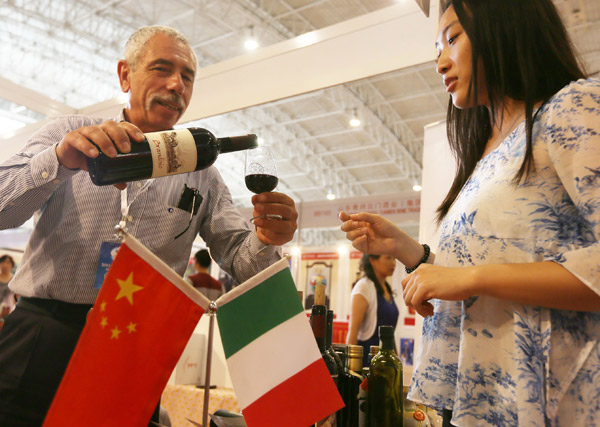 A man pours Italian wine at the Third China International Consumer Products Exhibition in Beijing. (Photo provided to China Daily)