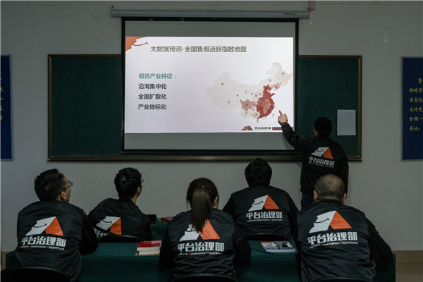 Members of Alibaba's Anti-Counterfeiting Task Force discuss the geographical distribution of fake goods during a briefing session. (Photo by Zhou Gangfeng/For China Daily)
