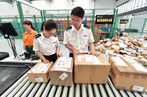 Customs officials in Yiwu, Zhejiang province, inspect e-commerce parcels from South Korea. (Photo by Lyv Bin/For China Daily)