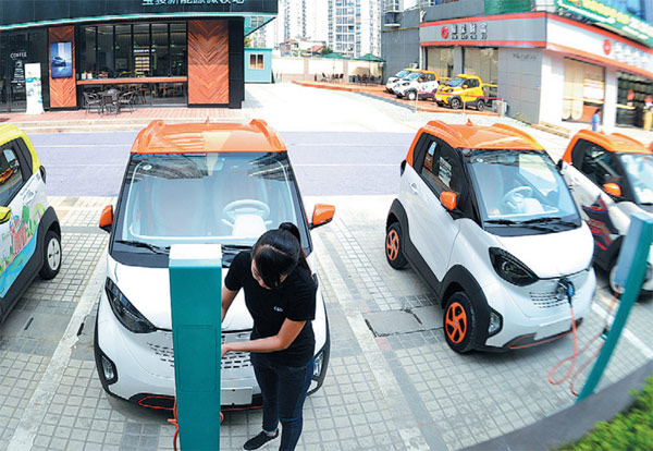 A woman charges a new energy vehicle in Liuzhou, Guangxi Zhang autonomous region. Strengthened supervision is urged to meet the rapid development of new energy vehicles in China. (Photo by Li Hanchi/For China Daily)