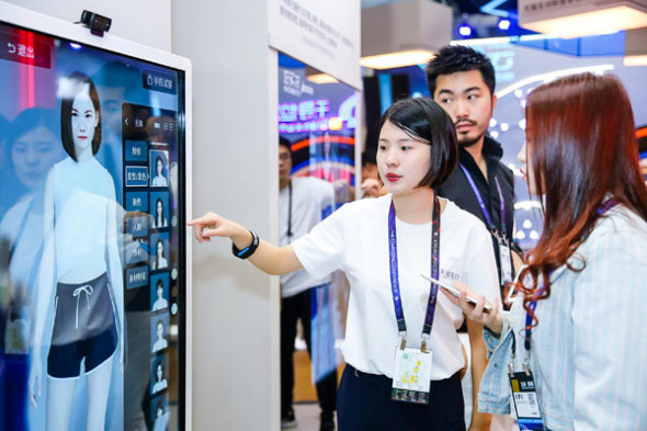 An Alibaba employee introduces a virtual mirror during the company's annual computing conference in Hangzhou, capital of Zhejiang province, Oct 11, 2017. (Photo by Niu Jing/For China Daily)