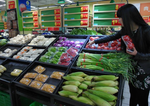 A customer chooses vegetables at a Walmart store in Yichang, Hubei province. Photo by Liu Fengjun/For China Daily