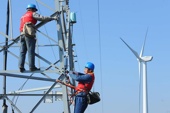 Workers with the power supply company in Chuzhou, Anhui province, check the transmission network under the State Grid before it is connected with a local wind power farm. SONG WEIXING / FOR CHINA DAILY