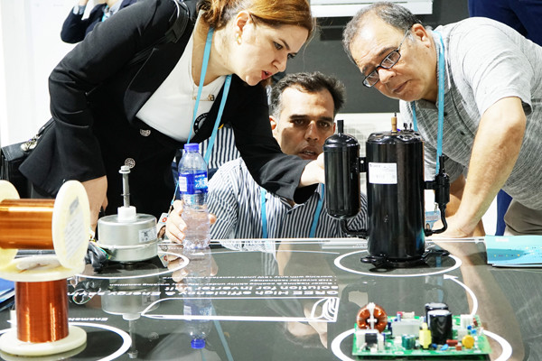 Exhibitors take a close look at an air-conditioner compressor developed by Gree Electric Appliances at the China Import and Export Fair in Guangzhou, Guangdong province, on Sunday. (Provided To China Daily)