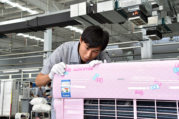 A worker inspects an air conditioner at the production line of Haier Group in Qingdao, Shandong province. (Photo/Xinhua)