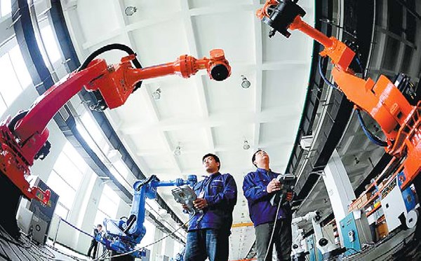 Workers test industrial robots at a Siasun Robot & Automation Co Ltd plant in Shenyang, Liaoning province. (Photo provided to China Daily)