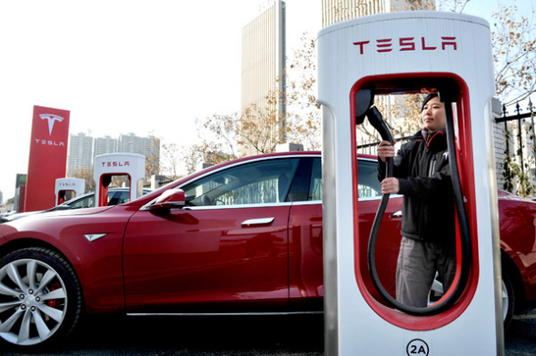 A driver uses Tesla's charging station in Xi'an, capital of Shaanxi province. (Photo by Liu Qiang/For China Daily)
