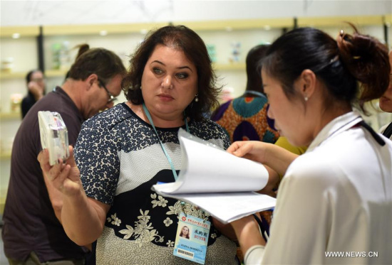 A woman selects crispers at the Phase 2 of China Import and Export Fair, or Canton Fair, in Guangzhou, capital of south China's Guangdong Province, Oct. 23, 2017. Highlighting consumer goods, gifts and home decorations, the phase 2 of the fair started on Monday and it will last for 5 days.(Xinhua/Lu Hanxin)