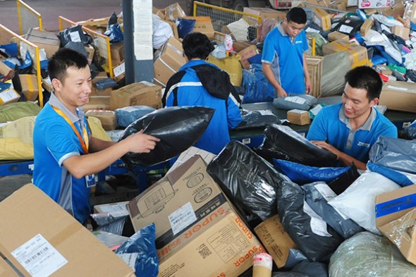 Employees of ZTO sort parcels in Fuyang, Anhui province. (Photo/for China Daily)