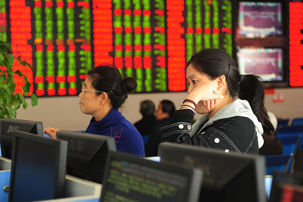 Investors check stock prices at a brokerage in Fuyang, Anhui province. The top leadership's call for sustainable development and green economic growth has boosted investor sentiment toward companies involved in environmentally friendly businesses. (Photo/for China Daily)