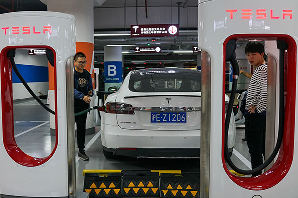 People charge their Tesla vehicles at a charging station inside a mall in Shanghai. (Photo/for China Daily)