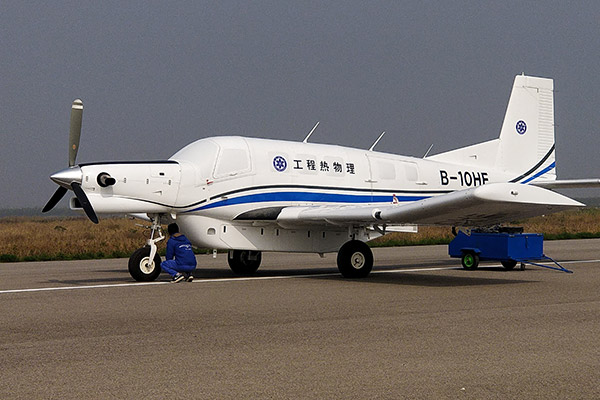 A technician checks an AT200, the world's largest transportation drone with a ton-level capacity, in Pucheng county, Shaanxi province. (Photo/Xinhua)