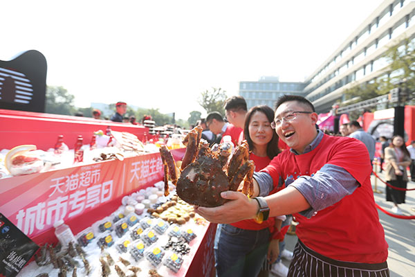 An employee from Tmall shows a hairy crab during a promotion for food products ahead of the Singles Day shopping gala in Hangzhou, Zhejiang province.(Provided to China Daily)
