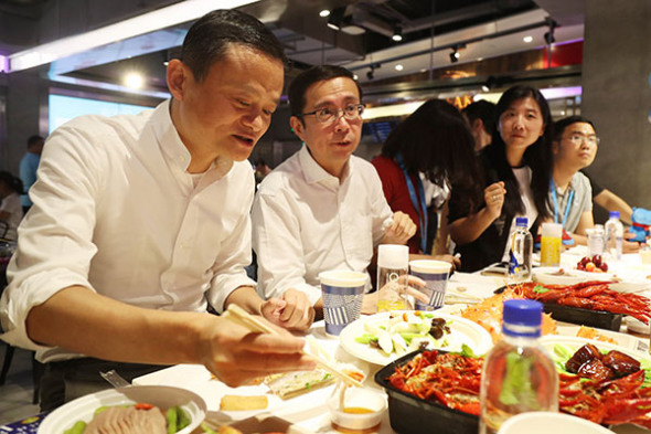 Jack Ma, the founder of Alibaba, savors the king crab he ordered at Hema Xiansheng, an emerging online-to-offline supermarket backed by Alibaba, in Shanghai in July.(Provided to China Daily)