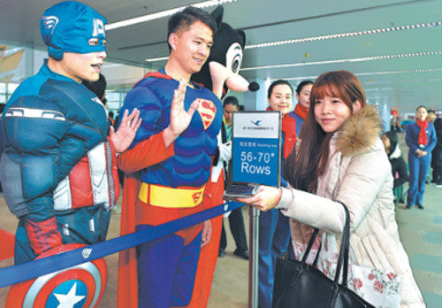 Workers in superhero costumes wave goodbye to passengers boarding Flight MF849, a direct service between Fuzhou, Fujian province, and New York. (Photo: Xinhua/Song Weiwei)