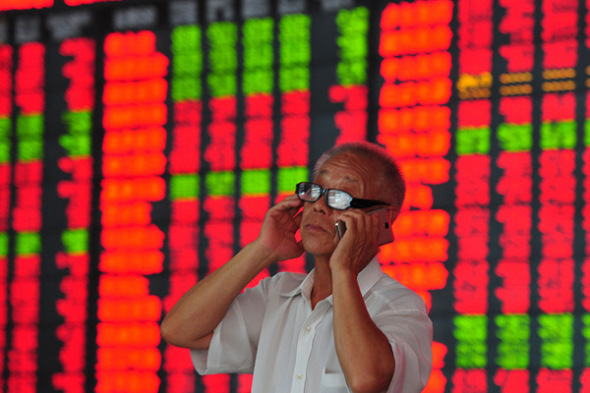 An investor discusses a market move on his smartphone from a brokerage in Fuyang, Anhui province, August 26, 2017. (Photo by An Xin/For China Daily)