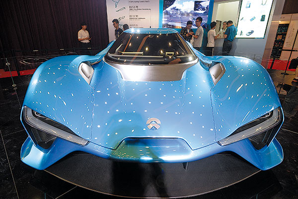 Visitors check out a NIO EP9 electric vehicles stand on display at an auto show in Beijing.(Fan Jiashan/China Daily)