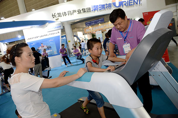 A boy tries an automated treadmill at a sports exhibition in Xi'an, capital of Northwest China's Shaanxi Province. (Photo/Xinhua)