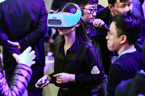A visitor checks out a Vive Focus at a developer conference held in Beijing. Users can enjoy the device without attaching it to personal computers or smart phones. (Photo provided to China Daily)