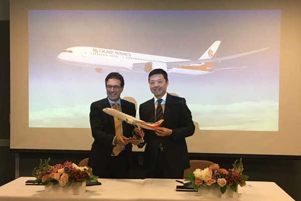 Li Zongling, president of Okay Airways, gives a model aircraft 787-9 with Okay's logo to Ihssane Mounir, senior vice-president of global sales and marketing for Boeing Commercial Airplanes, at a signing ceremony in Seattle. (Photo/China Daily by Linda Deng)