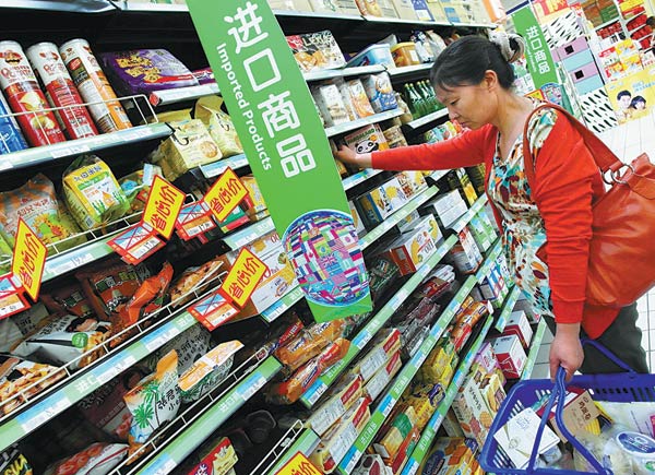 A customer selects imported biscuits, cookies and crackers at a supermarket in Yichang, Hubei province. (Photo provided to China Daily)
