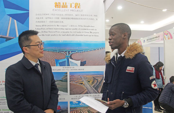 An African studying in China talks with a Chinese employer at the job fair in Beijing on Nov 15. (Photo/China Daily)