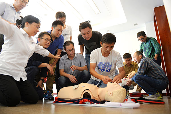 Volunteers from International SOS organize a first-aid training demonstration in Beijing.(Photo by Hu Qingming/China Daily)