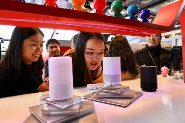 Visitors listen to intelligent speakers at the Light of the Internet Exposition, which is part of the 4th World Internet Conference in Wuzhen, Zhejiang province. (Photo by Zhu Xingxin/China Daily)