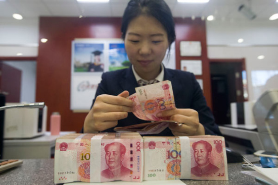 A teller counts money at a bank in Taiyuan, capital of North China's Shanxi province. [Photo/China News Service]