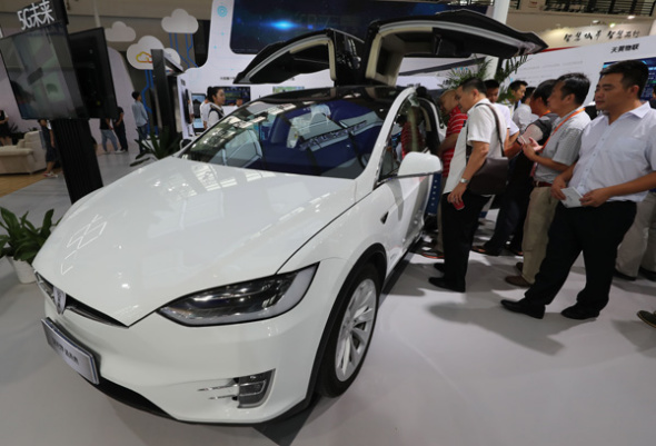 Visitors check out a Tesla intelligent car displayed at the 2017 Seventh China Smart City Technology and Application Products Expo in Ningbo, Zhejiang province, on Sept. 8.  (Photo provided to China Daily)