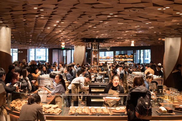Customers select beverages and food items at the Starbucks Reserve Roastery in Shanghai. The store, which covers 2,700 square meters, is its largest outlet in the world. (Photo by Gao Erqiang/China Daily)