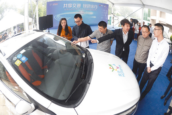 Local residents visit Beijing's first car-sharing service station in Shijingshan district. (Photo by Shou Yiren/For China Daily)