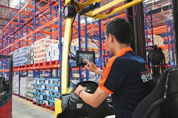 A Transfar Zhilian employee uses an internet app to sort deliveries in the company's warehouse. (Photo provided to China Daily)