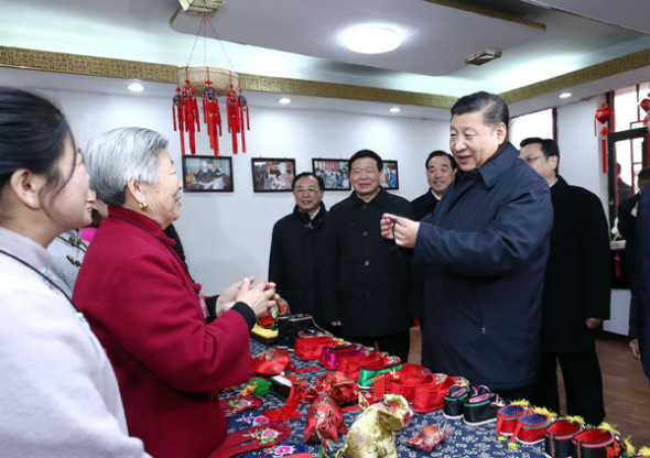 President Xi Jinping speaks with villager Wang Xiuying, 80, who made a herbal sachet that he admired and wanted to buy in the Xuzhou village of Mazhuang in Jiangsu province on Tuesday. Xi, on an inspection tour, paid 30 yuan ($4.50) for the sachet. (Photo/Xinhua)