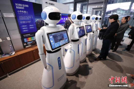 Visitors interact with an intelligent robot at the fourth World Internet Conference in Wuzhen, Tongxiang City of east China's Zhejiang Province, Dec. 4, 2017. (Photo: China News Service/Du Yang)