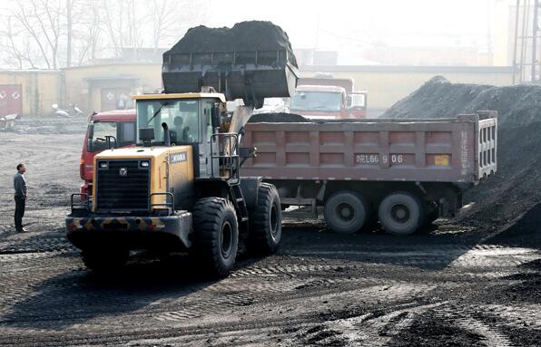 Coal is loaded onto trucks at a coal mine warehouse in Huaibei, East China's Anhui province. (Photo by Hoo Mei/For China Daily)