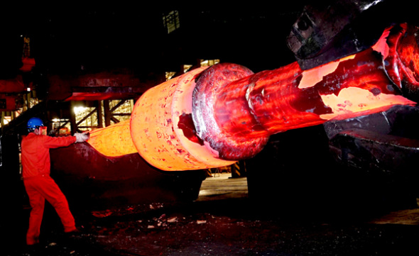 A technician measures a rotor spindle at a steel plant in Dalian, Liaoning province. (Photo by Liu Debin/For China Daily)